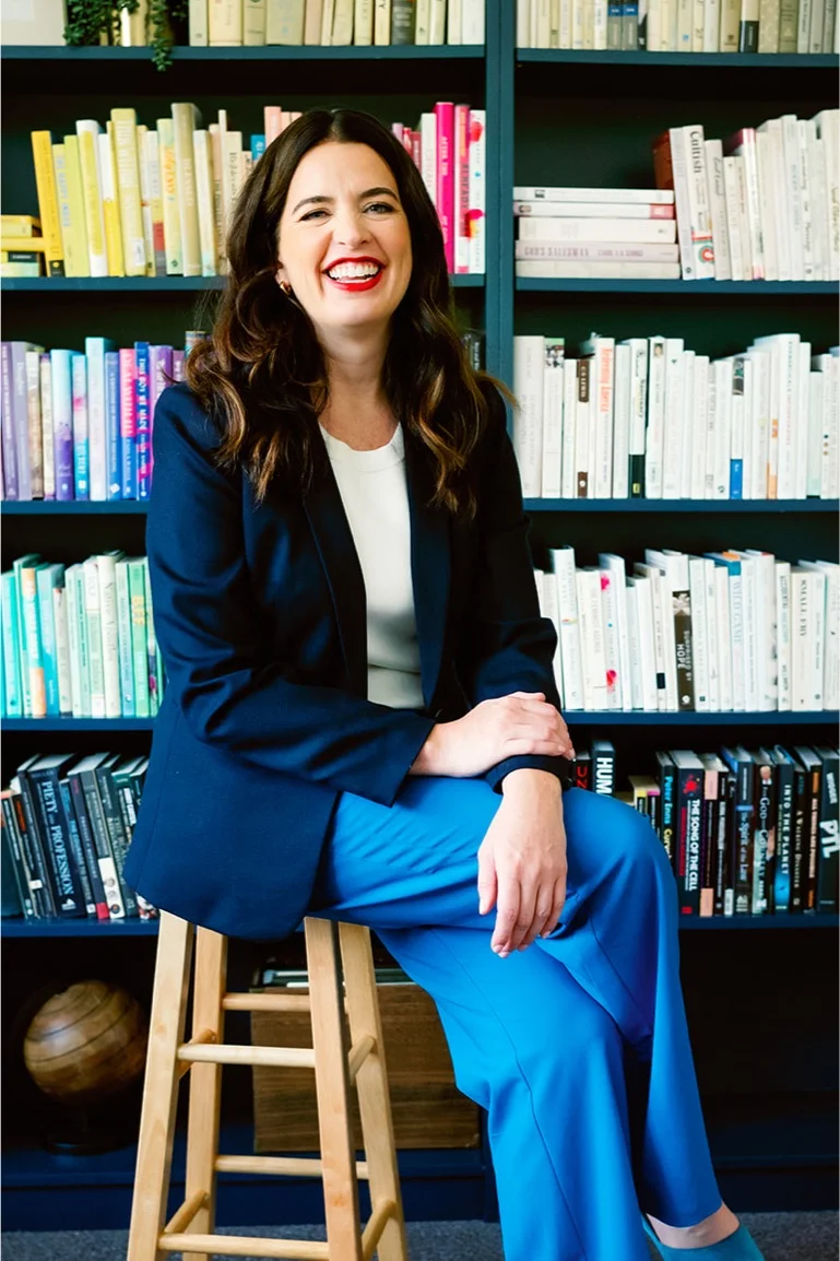 Kate Bowler sitting in front of books